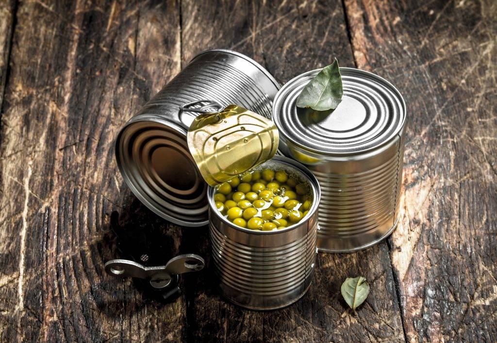 Canned green peas in a tin can with opener.