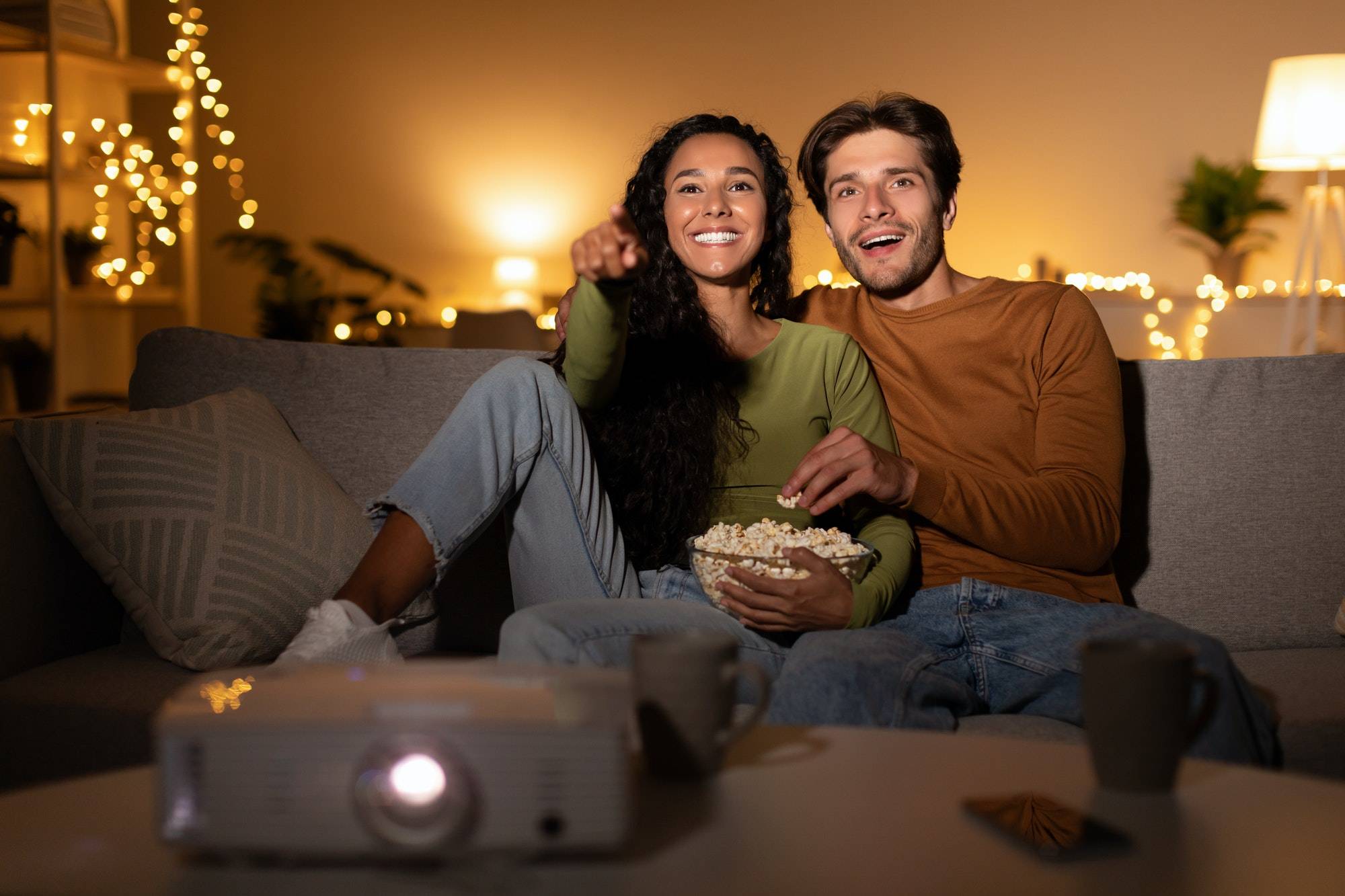 Boyfriend And Girlfriend Watching Movie Via Projector At Home