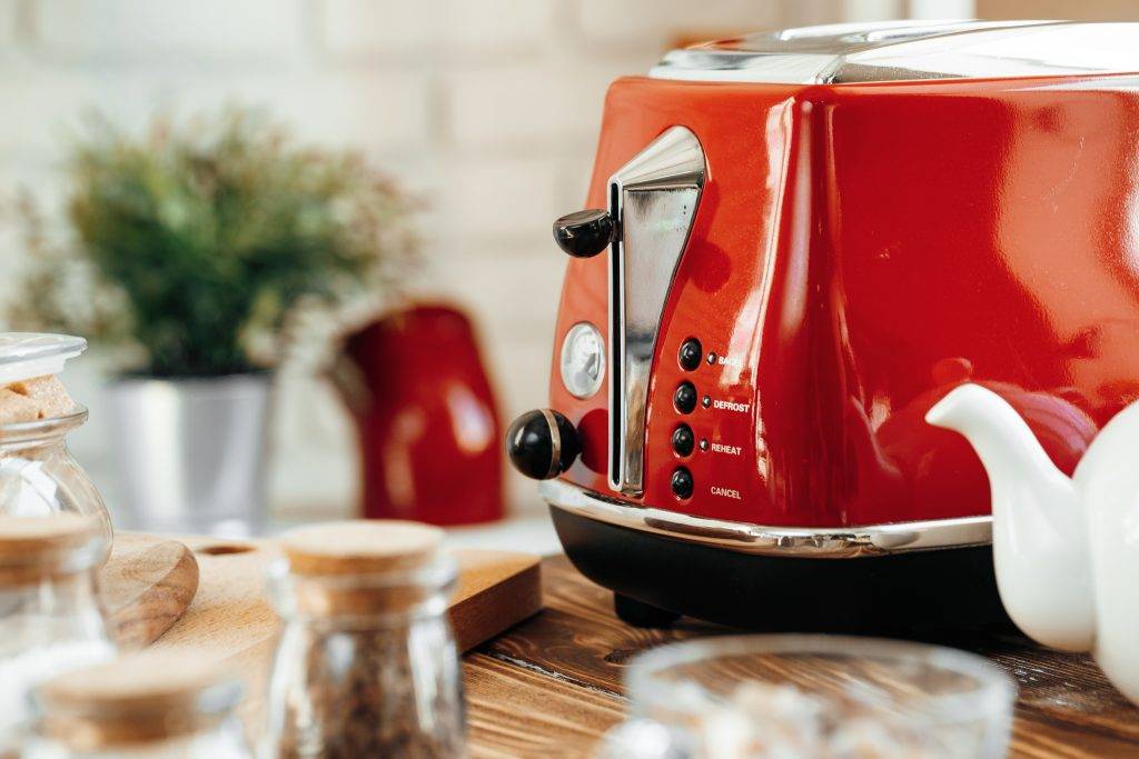 Ceramic teapot and toaster, kitchen table close up