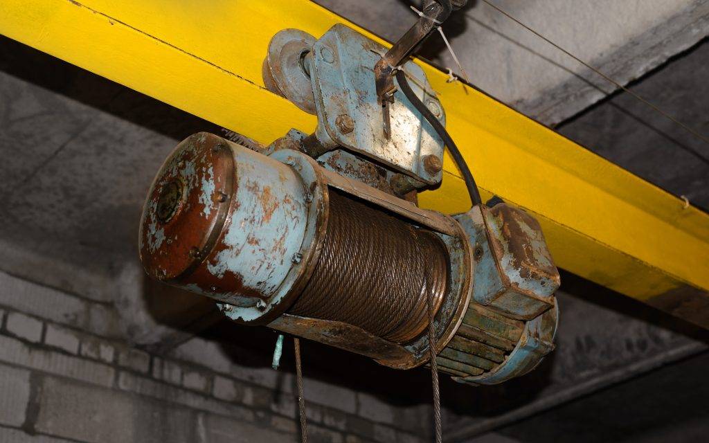 Electric hoist industrial equipment in garage. Electrically powered overhead hoist, provides
