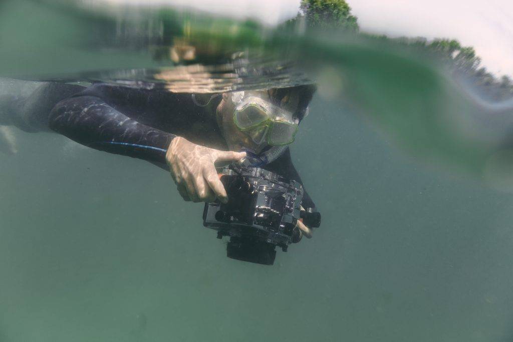 Man diving with underwater DSLR camera case