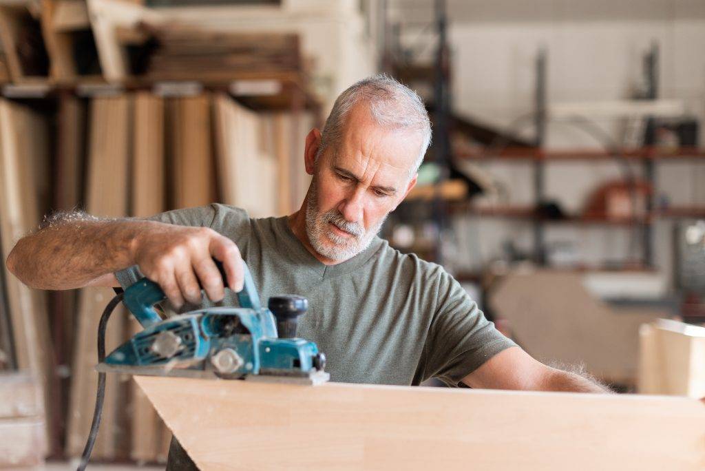 Man planing wood with a hand planer