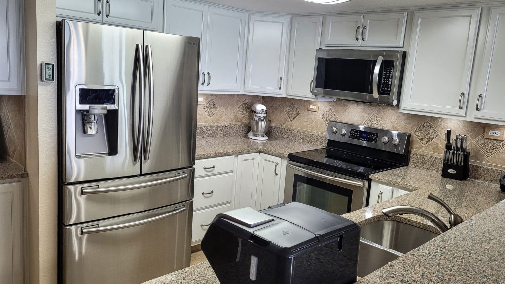 New kitchen in beach condo with smart refrigerator and granite countertops in the remodel.