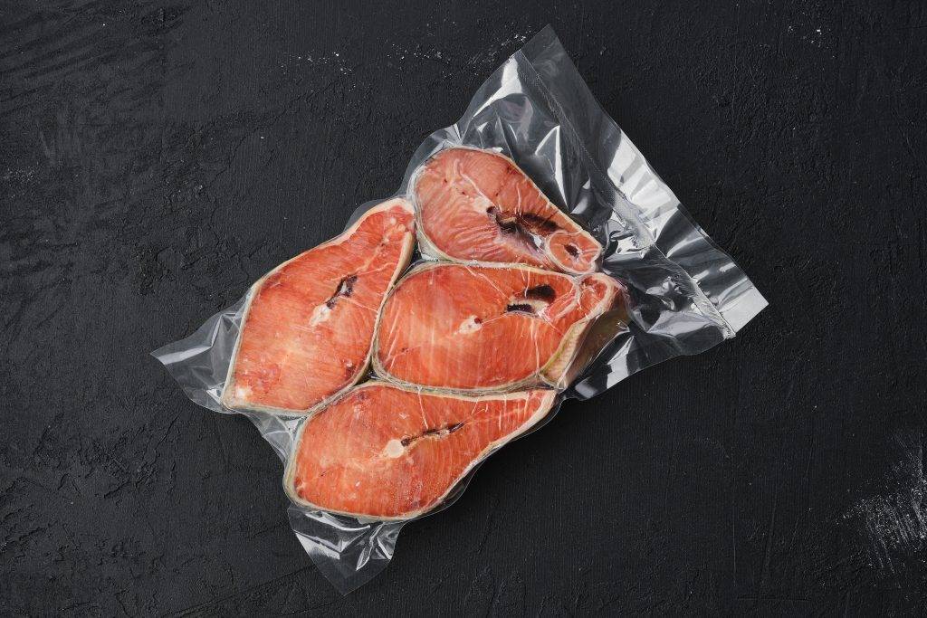 Overhead view of raw salmon steak in vacuum packaging