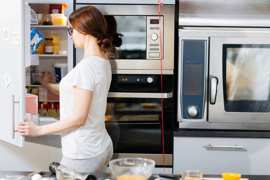 Woman by refrigerator