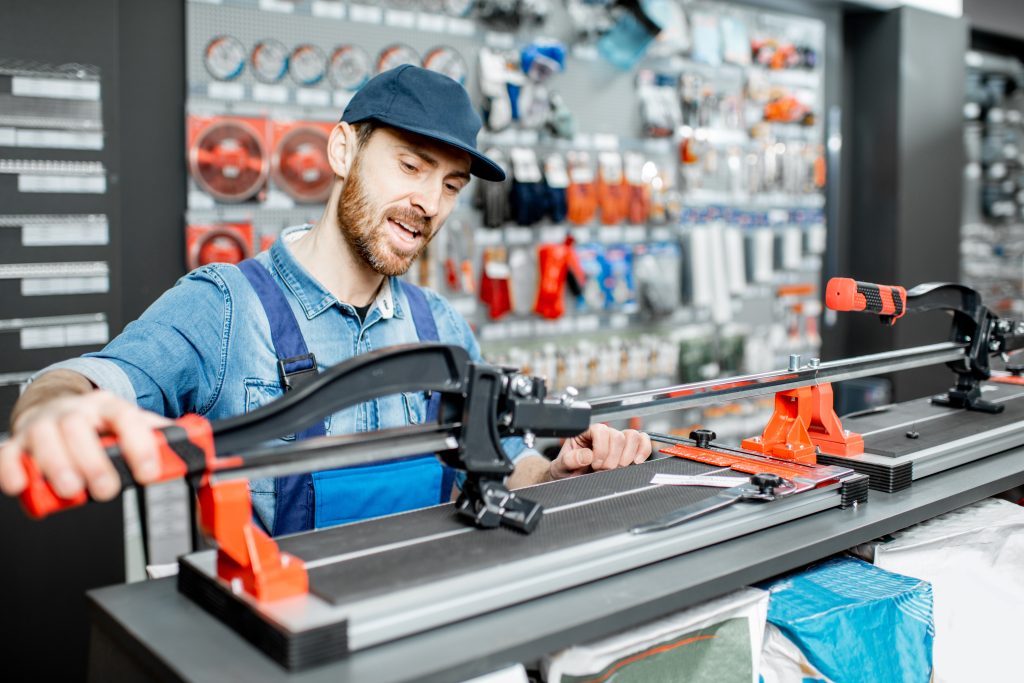 Workman with tile cutter in the building shop