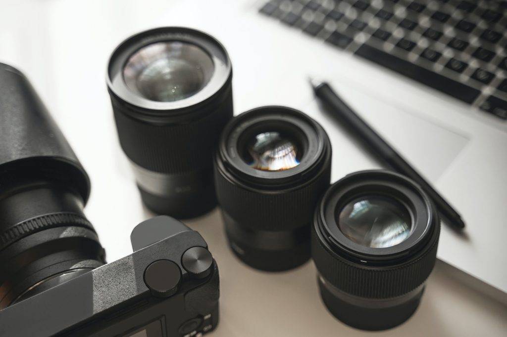 Workplace with a modern equipment for photography. Mirrorless camera and prime lenses.