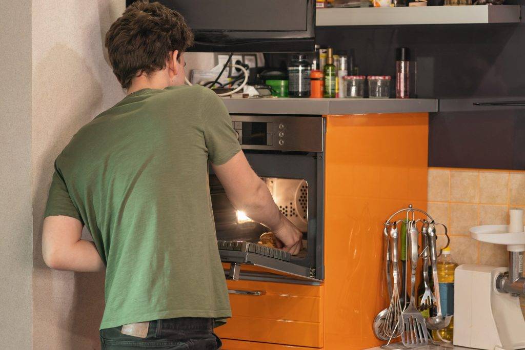 young man warms up dinner in the microwave