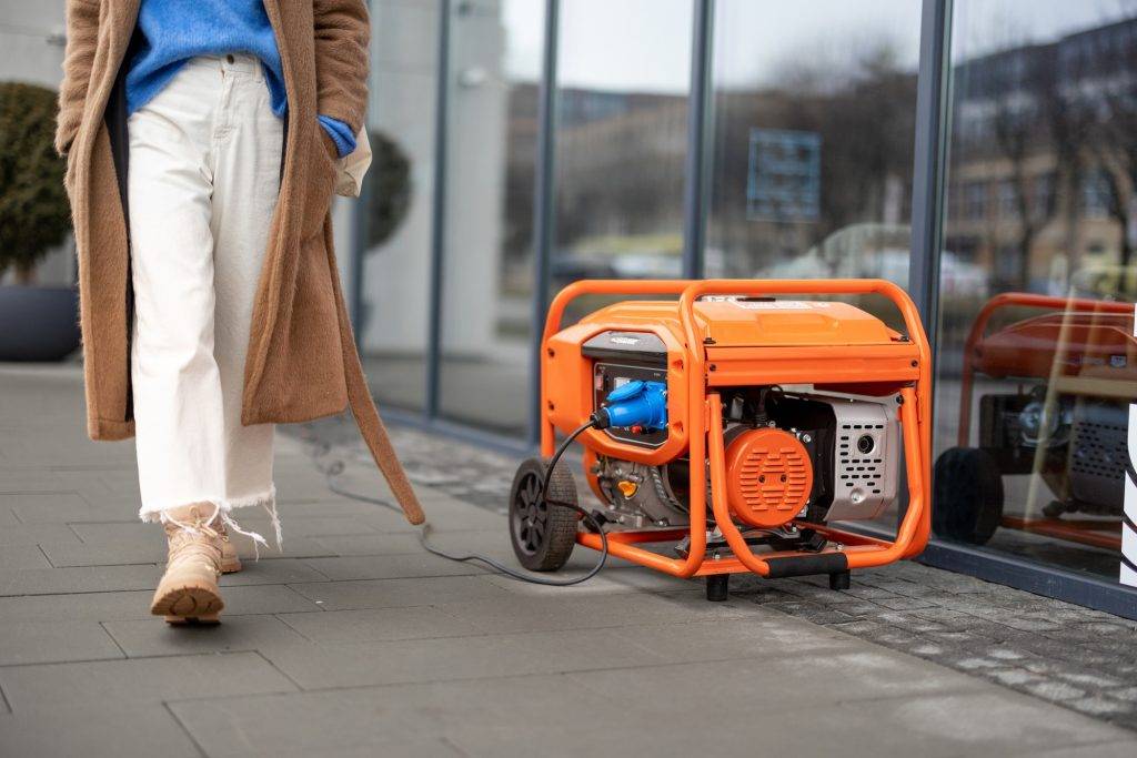 Woman walks on a street with gasoline generator