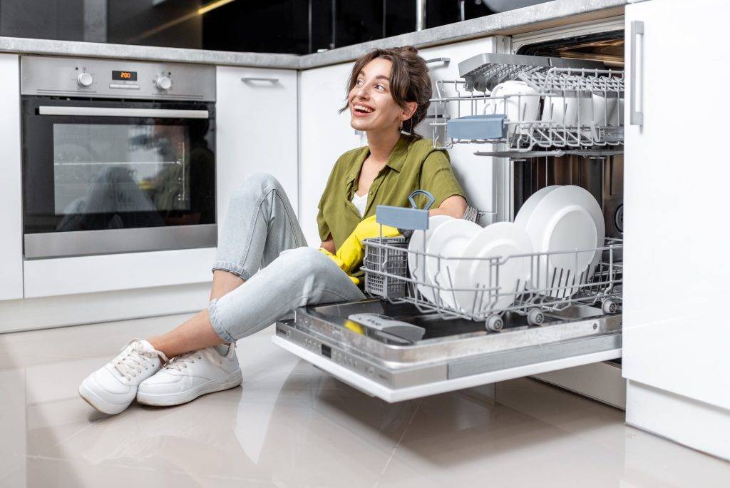 Housewife near the dishwasher at home