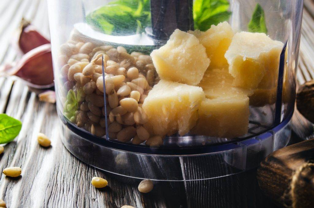 Ingredients for italian national traditional genovese pesto sauce in food processor bowl